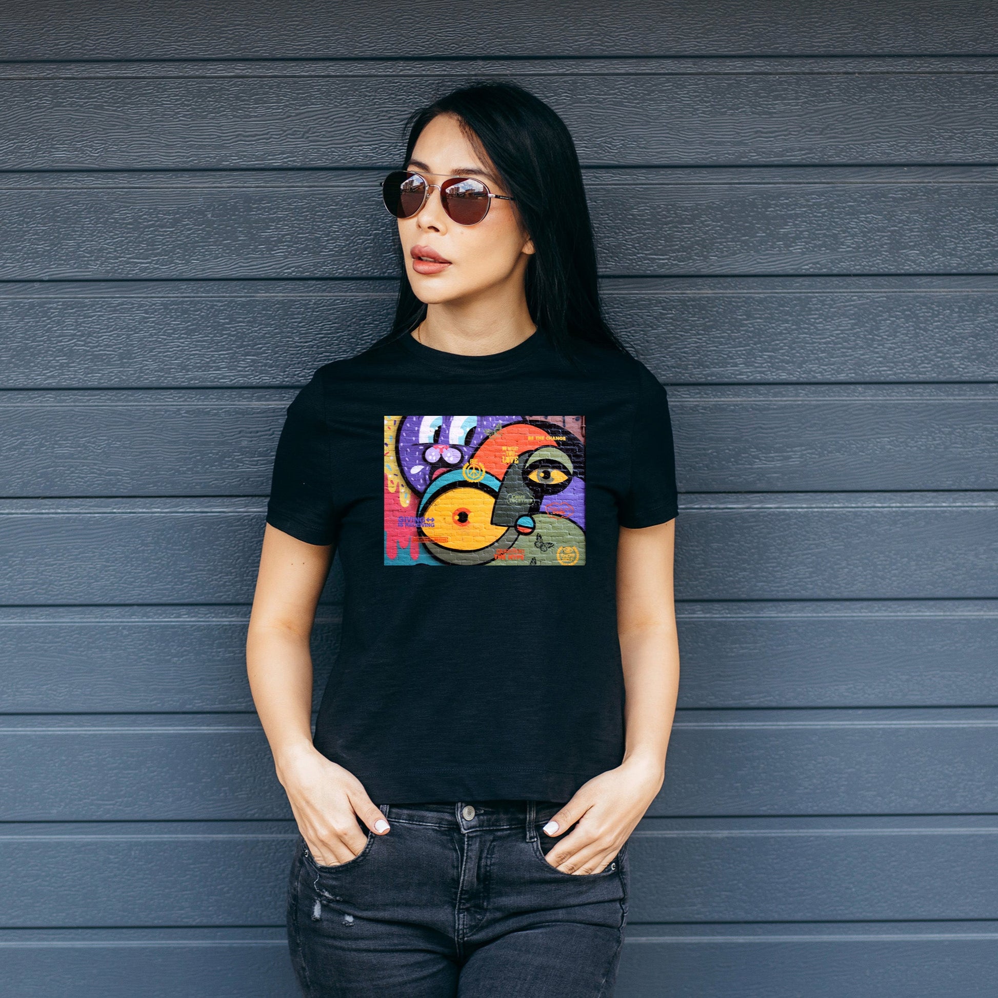 Woman wearing a black t-shirt with a colorful graffiti print.
