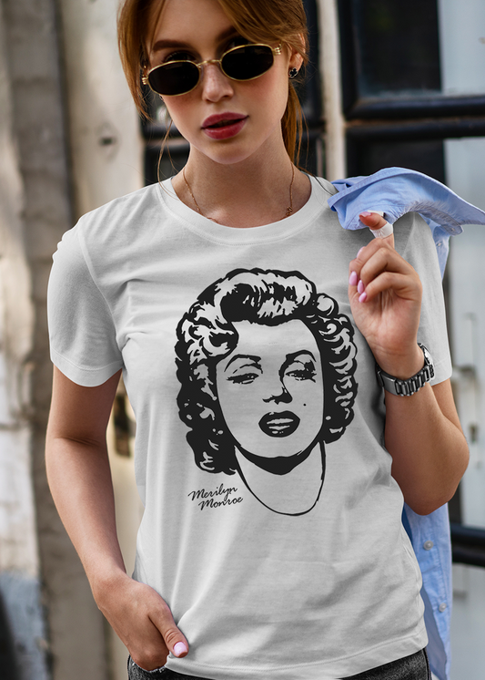 Person wearing a white t-shirt with an image of Marilyn Monroe, standing against an urban background.