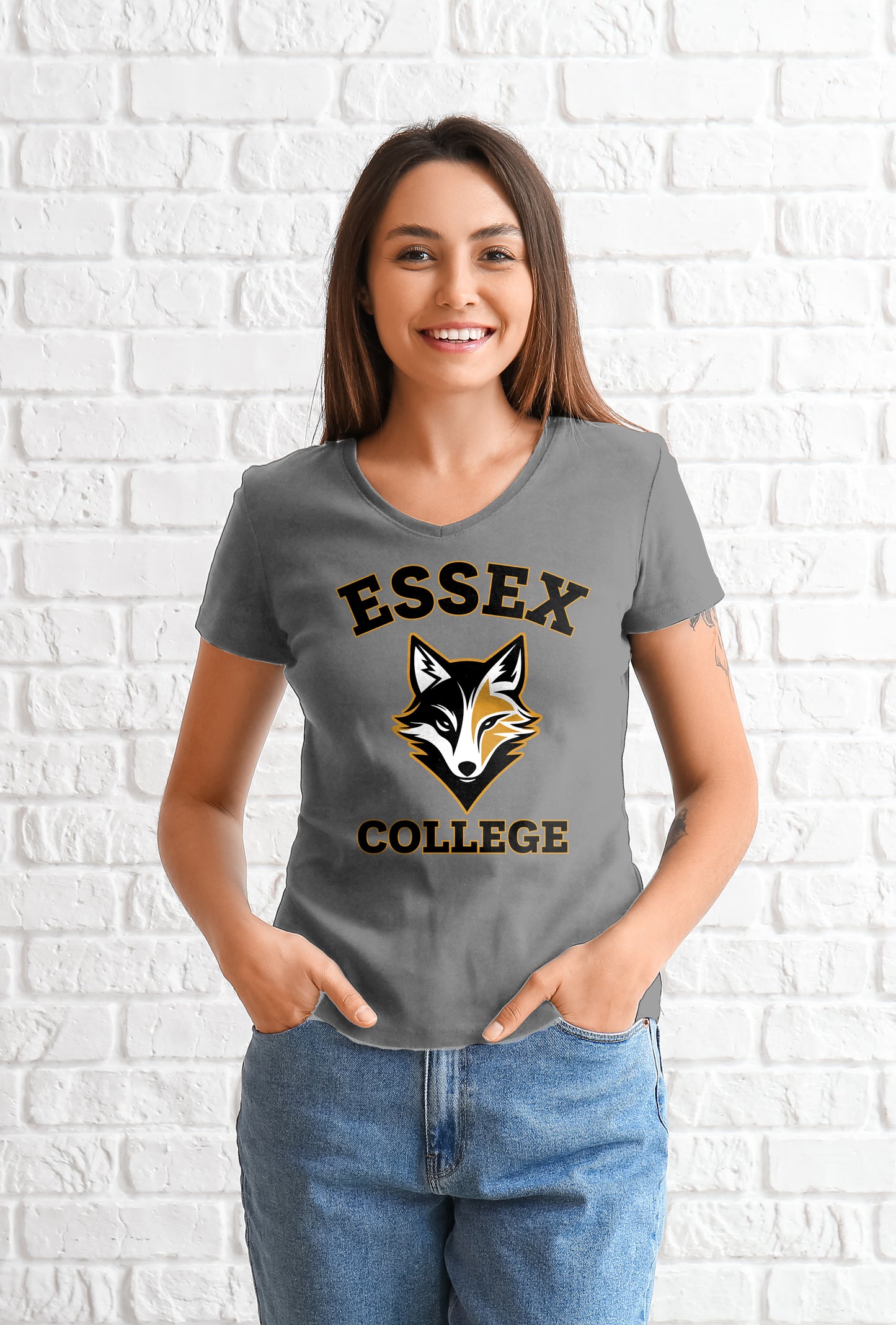 Woman wearing a gray t-shirt with 'Essex College' and a fox logo against a white brick wall.